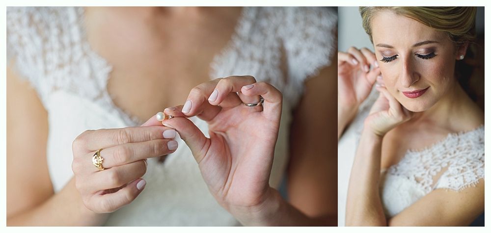 Bride adjusting jewelry on her wedding day. She wears a lace dress and has makeup on.