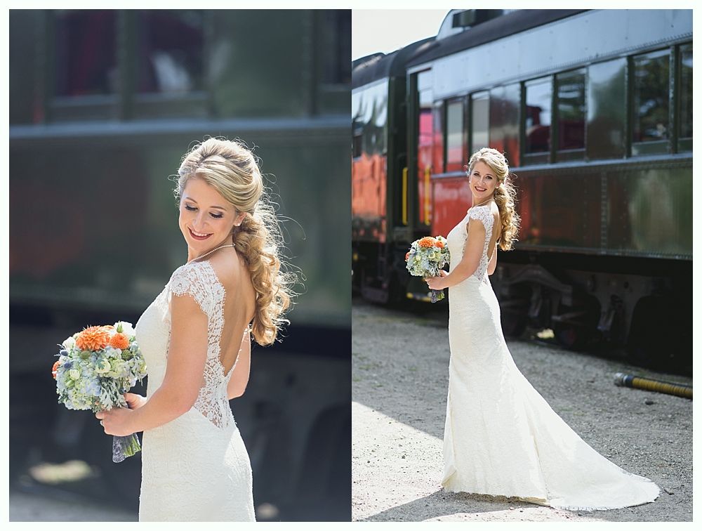 Bride in open-back dress holds flowers, smiles, and poses next to a vintage train.