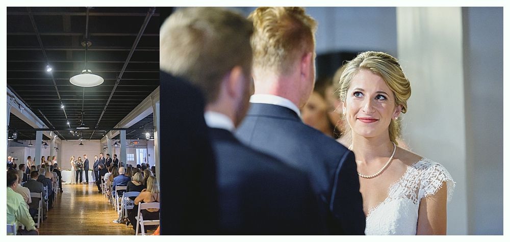 Bride smiles at groom during wedding ceremony. Guests in background.