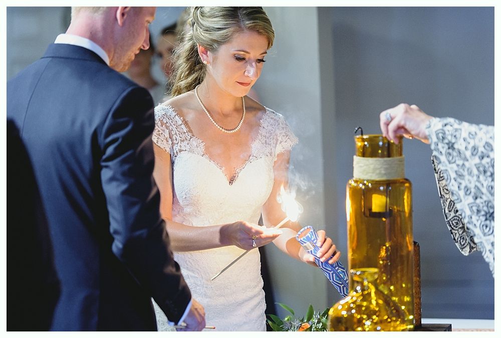 Bride and groom lighting a unity candle during a wedding ceremony.