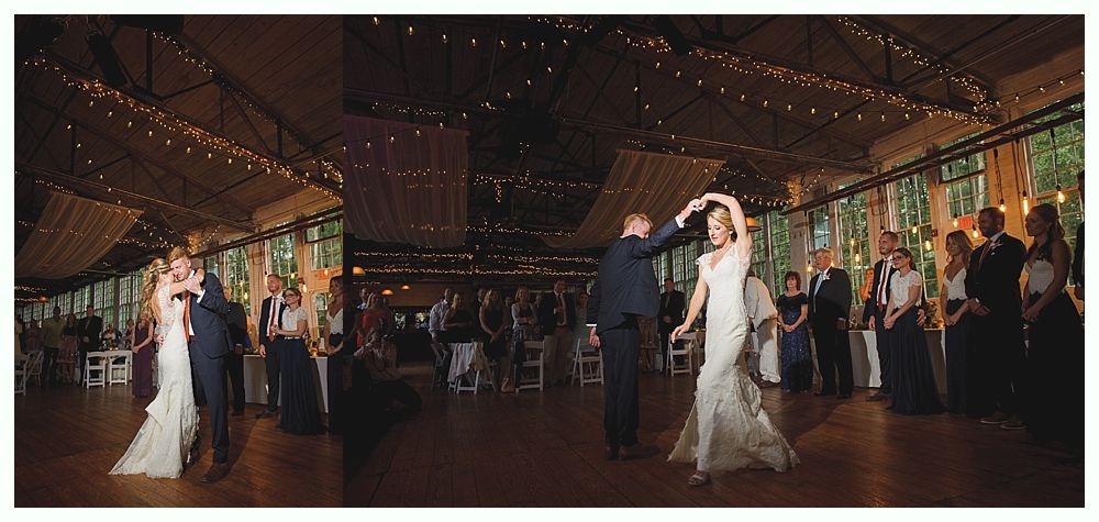 Bride and groom dance at their wedding reception in a large hall with string lights and tall windows.
