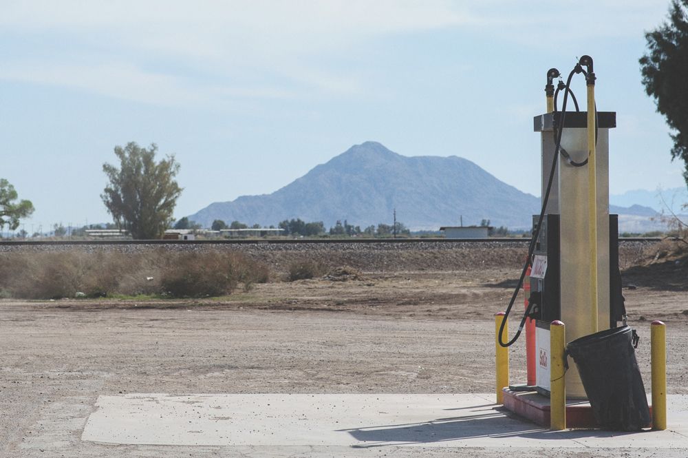 Wedding couple embraces, lit by bright flash. Stairs in background. Black and white.