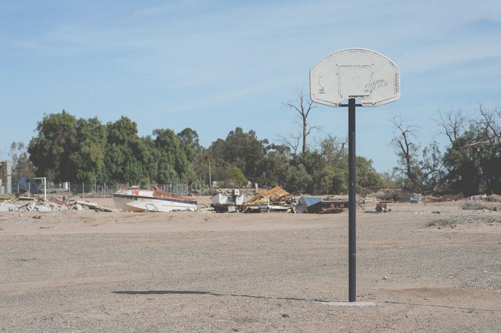 Person taking photo in mirror, indoors; black and white.