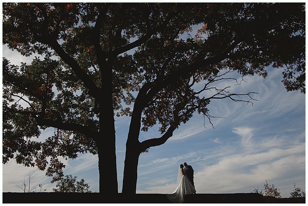 Woman in a crowd, smiling and resting her chin on her hand, at an outdoor event.