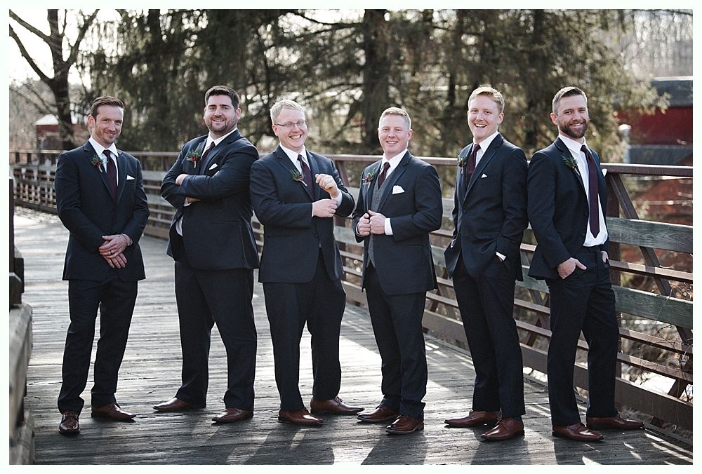Wedding ceremony outdoors under a tree, guests seated. Couple, bridal party at altar. Autumn foliage.