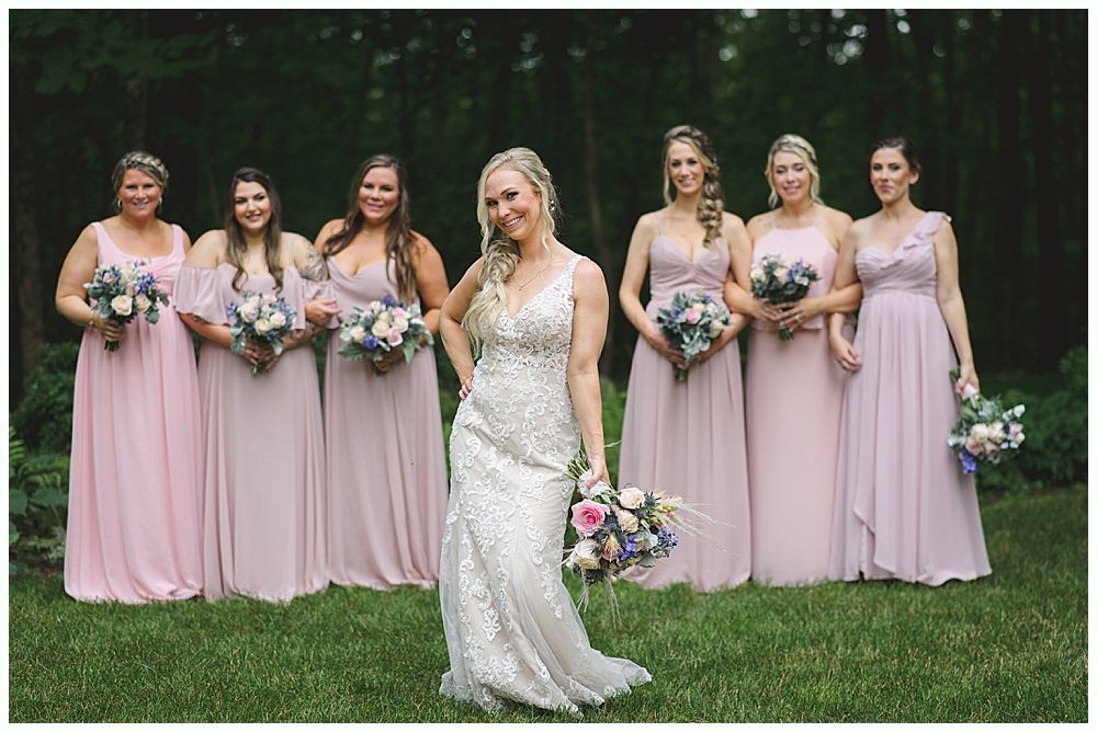 Wedding ceremony outdoors under a tree, guests seated. Couple, bridal party at altar. Autumn foliage.