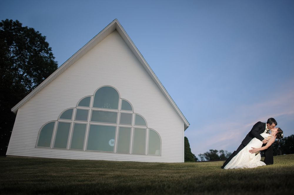 Person taking photo in mirror, indoors; black and white.
