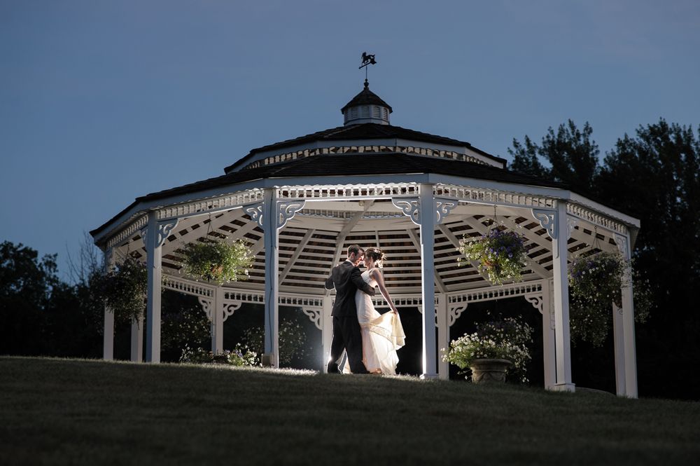 Person taking photo in mirror, indoors; black and white.