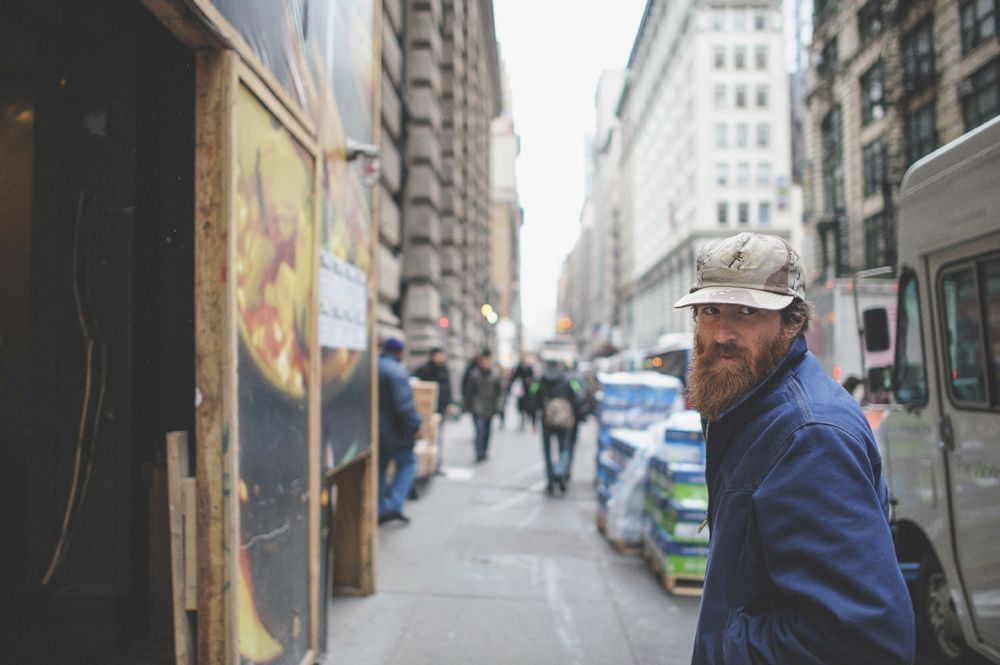 Person taking photo in mirror, indoors; black and white.