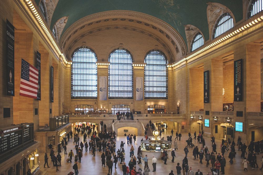 Person taking photo in mirror, indoors; black and white.