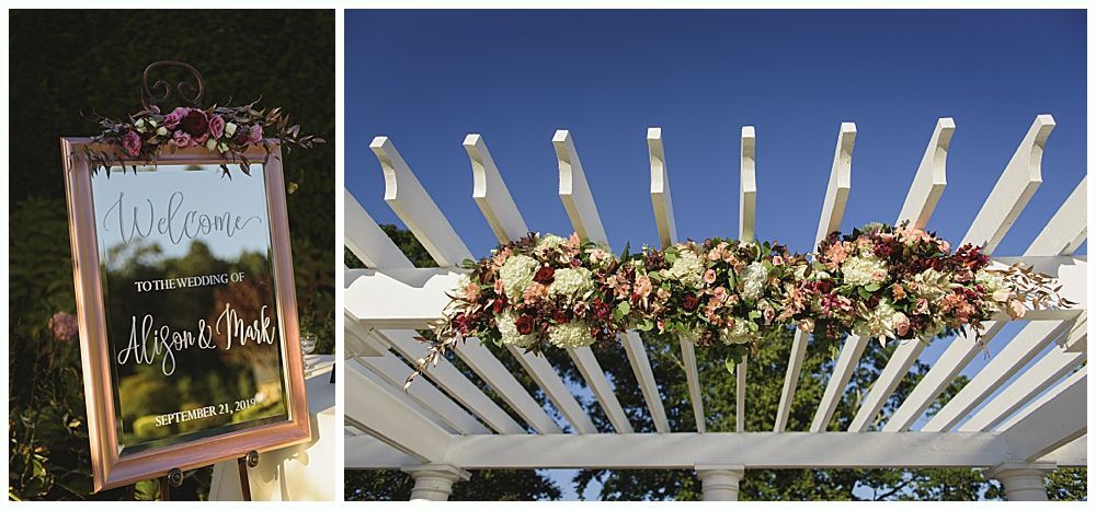 Wedding party smiling outdoors near water. Bride and bridesmaids in red, groom and groomsmen in navy.