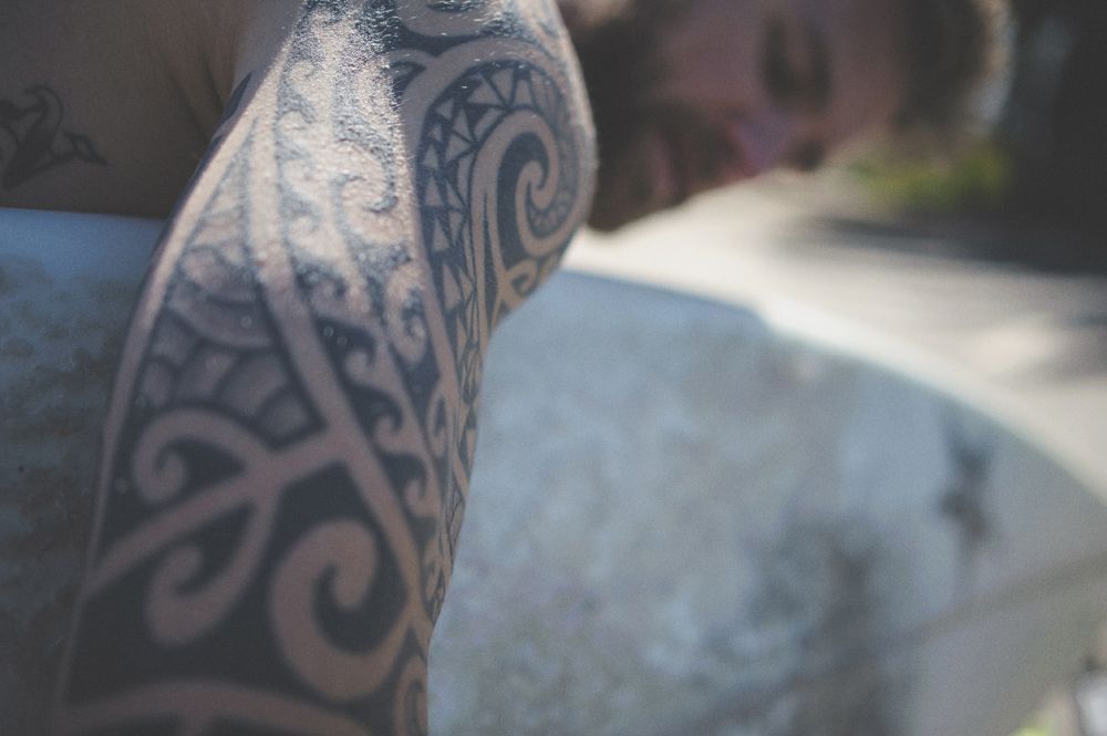 Man in suit looks out a window, checking his watch, waiting. Black and white.