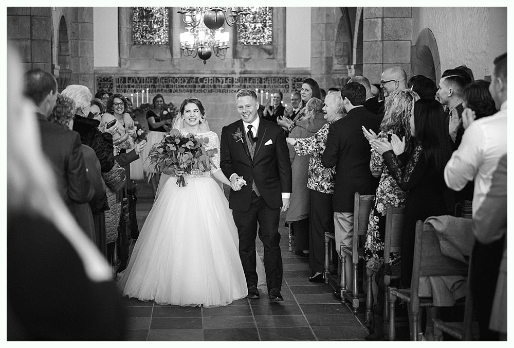 Barn interior with guests, food tables, and hanging glass globe lights.