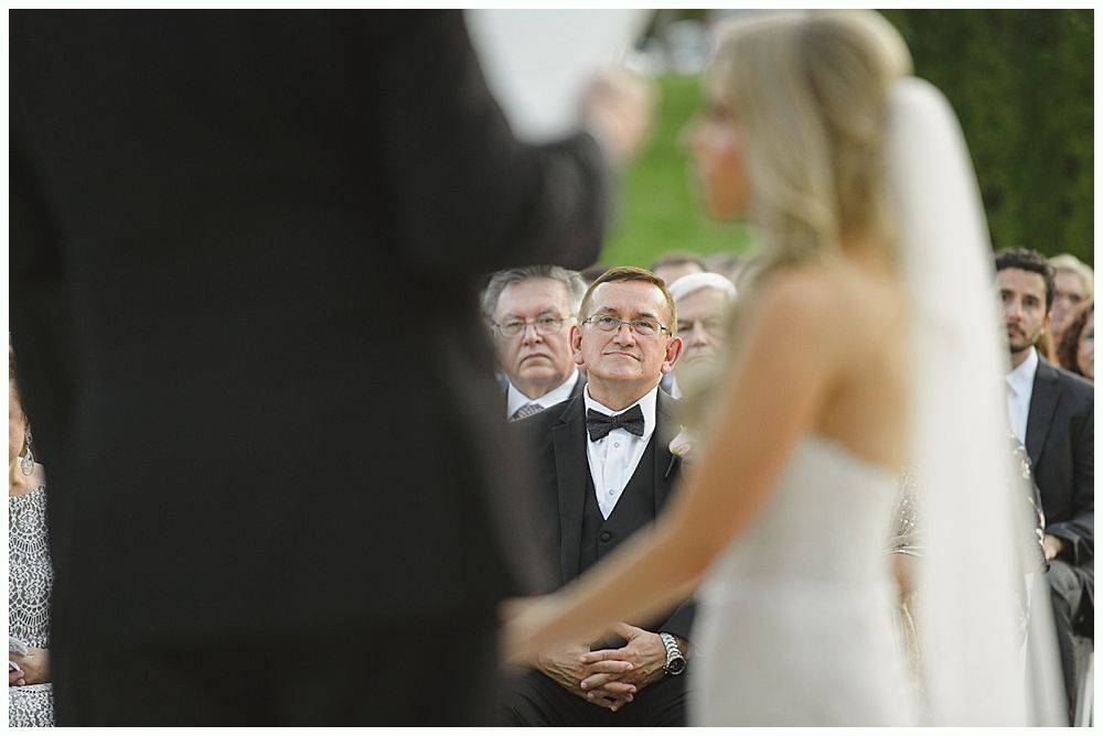 Barn interior with guests, food tables, and hanging glass globe lights.