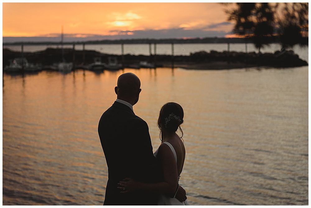 Barn interior with guests, food tables, and hanging glass globe lights.