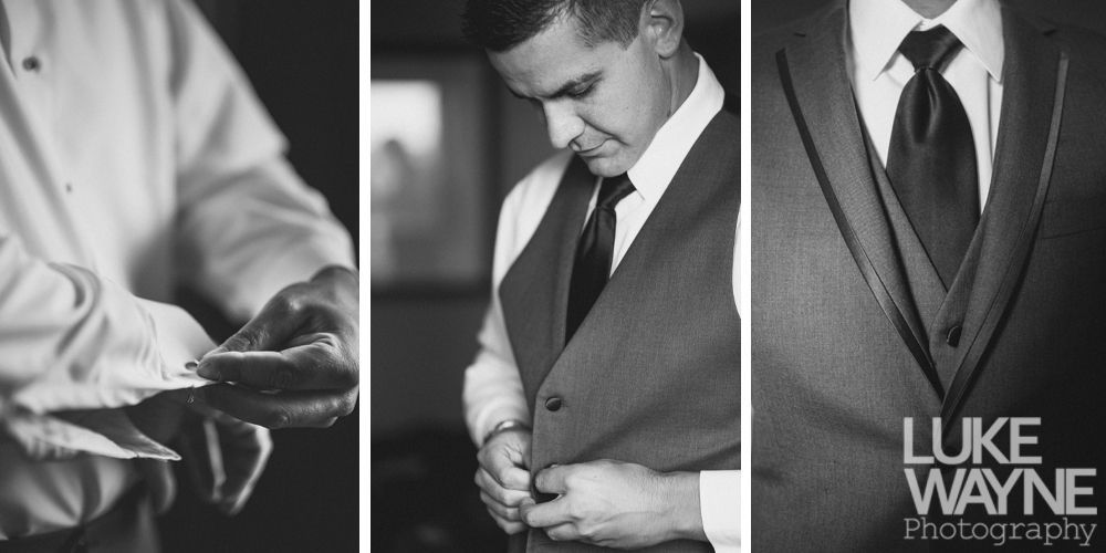 Man adjusting his suit: buttons, tie, and cufflinks. Black and white.