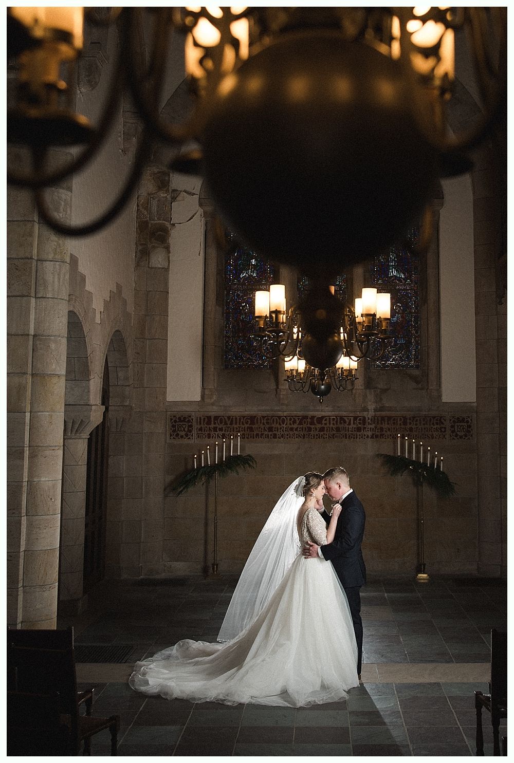 Wedding reception: couple dancing in a dark venue. Guests watch from tables.