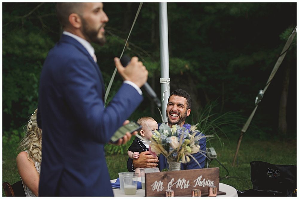 Couple dances at a wedding reception; chandelier and string lights in background.