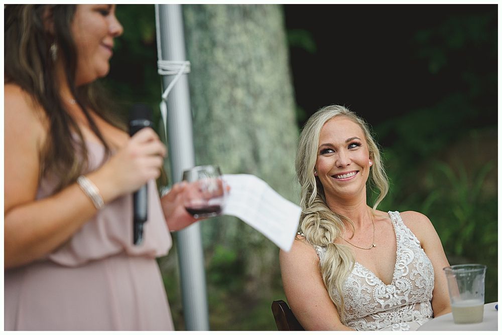 Newlyweds embrace on a dance floor, surrounded by guests at a wedding reception.