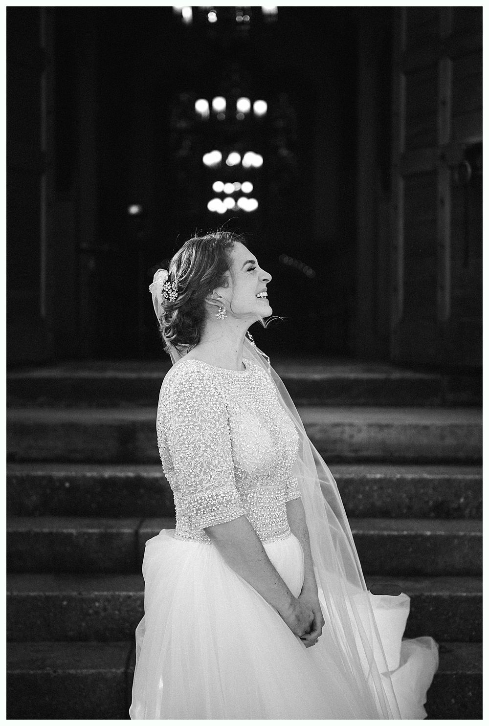 Newlyweds embrace on a dance floor, surrounded by guests at a wedding reception.