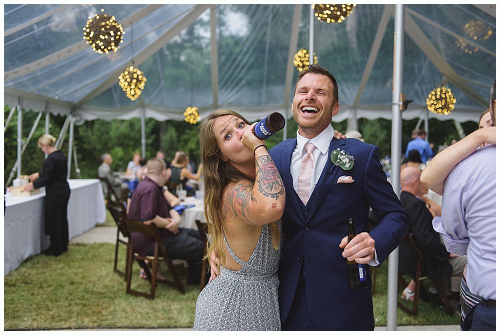 Woman in red dress giving a speech at a wedding. Bride smiles. Wooden interior.