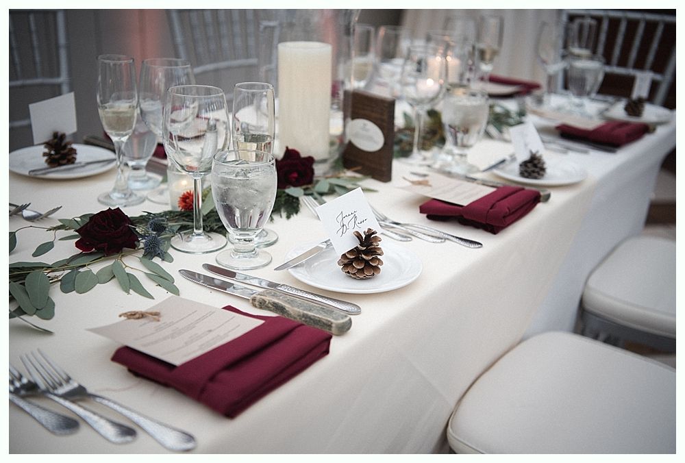 Woman laughs at a formal dinner, seated next to a smiling man with a yellow tie; table setting.