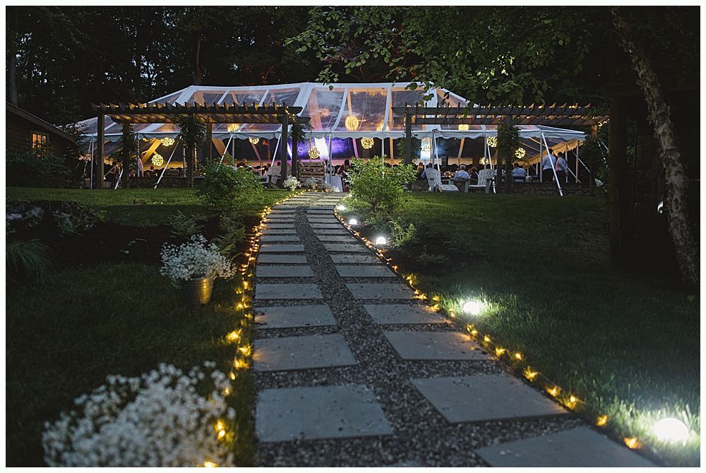 Man in suit laughing with mouth wide open at an event.