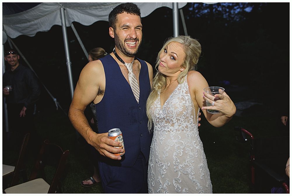 Wedding cake with figurines, on a wood slice. Rustic decor with blurred lights in the background.