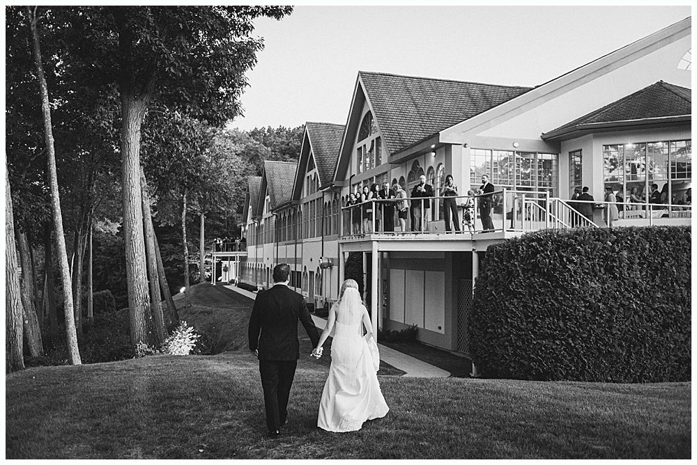 Man in suit laughing with mouth wide open at an event.