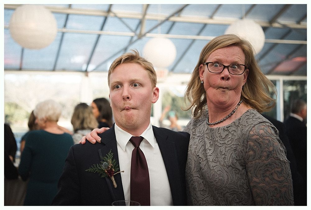 Wedding cake with figurines, on a wood slice. Rustic decor with blurred lights in the background.