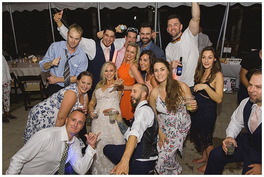 Wedding cake with figurines, on a wood slice. Rustic decor with blurred lights in the background.