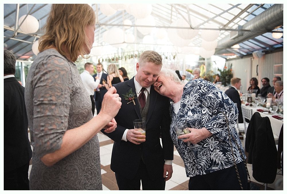 Wedding cake with figurines, on a wood slice. Rustic decor with blurred lights in the background.