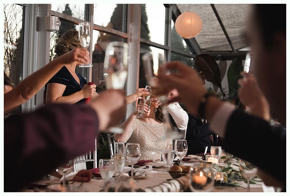 Wedding cake with figurines, on a wood slice. Rustic decor with blurred lights in the background.