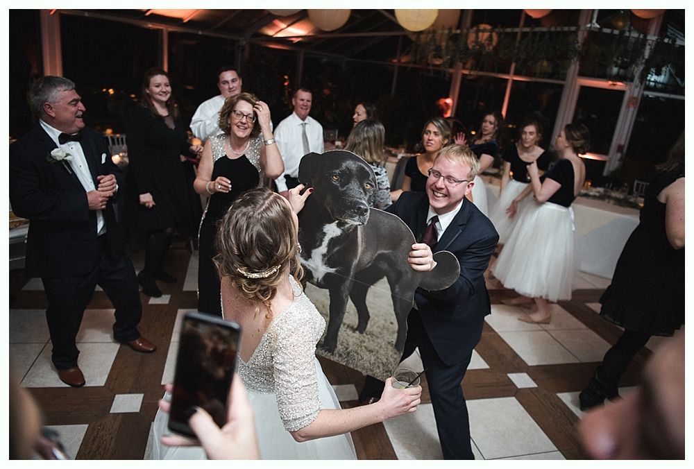 Wedding cake with figurines, on a wood slice. Rustic decor with blurred lights in the background.