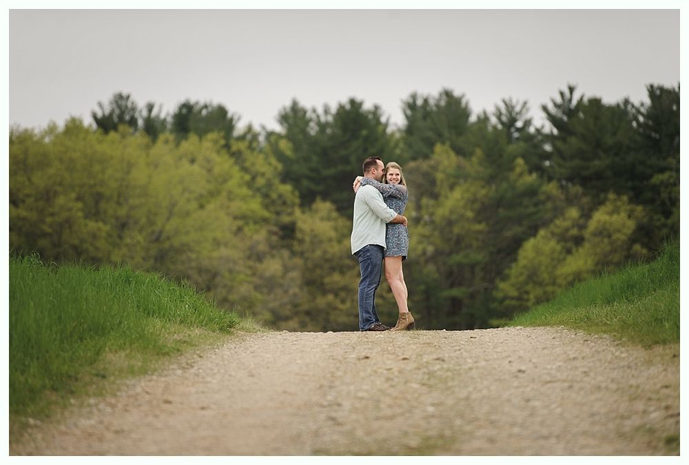 Bride in white dress with bridesmaids in red holding bouquets, smiling outdoors.