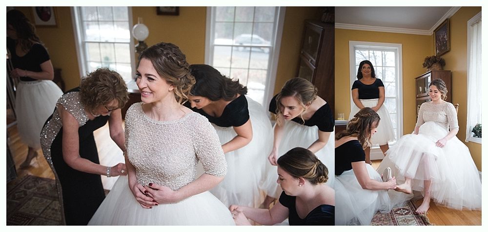 Bride in white dress with bridesmaids in red holding bouquets, smiling outdoors.