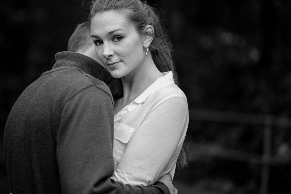 Bride in a white strapless gown adjusts her earring, then smiles holding sunflowers; indoors, window light.