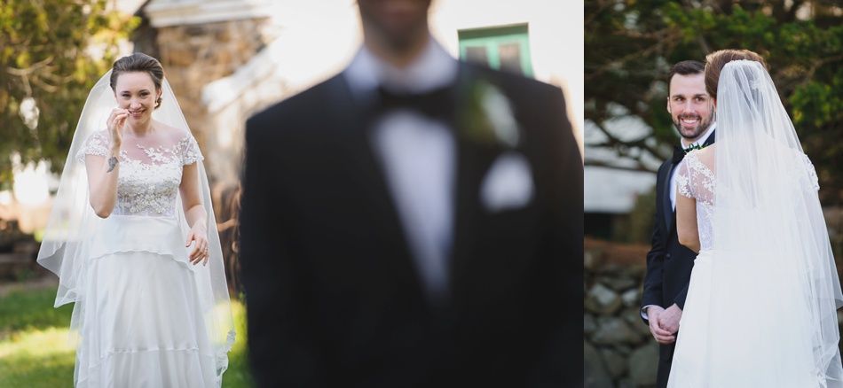 Bride with arms up, making a funny face, groom looking at his hand, cake cutting in background.