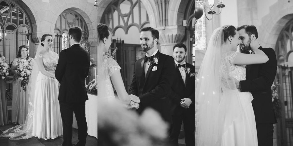 Bride with arms up, making a funny face, groom looking at his hand, cake cutting in background.