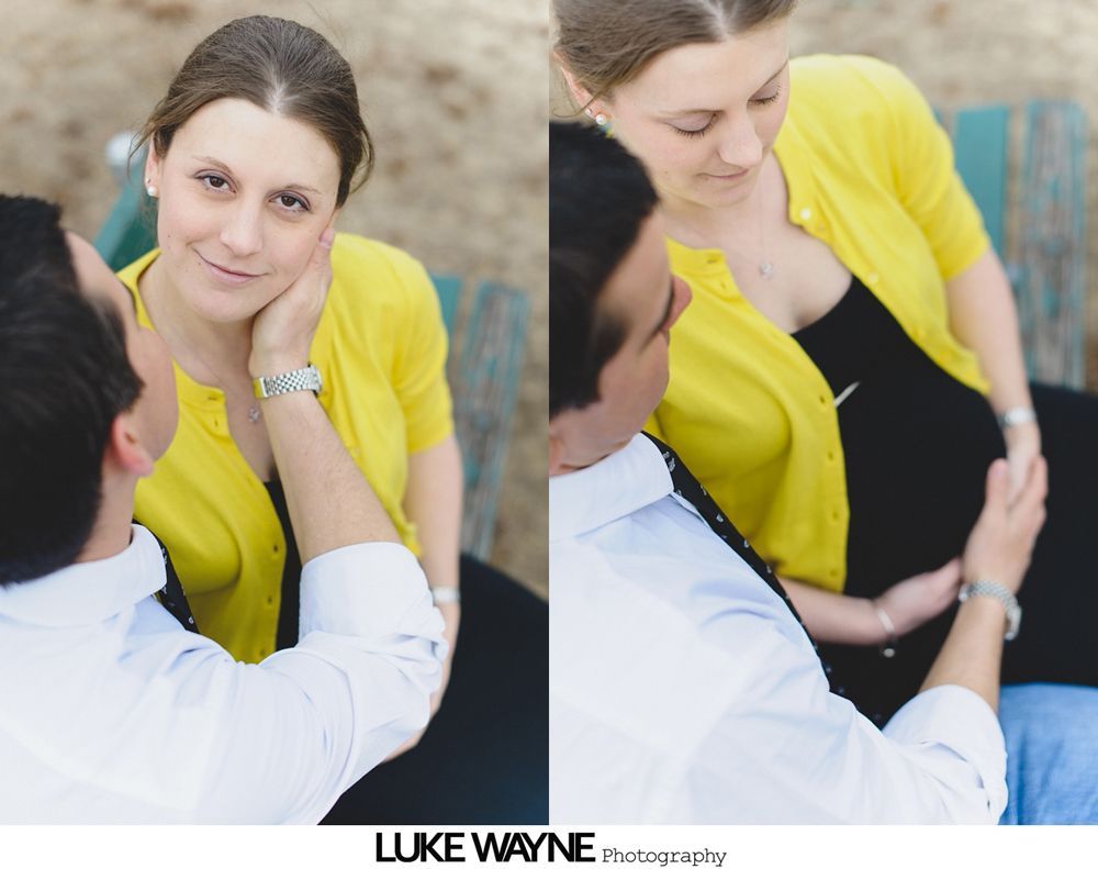 Pregnant woman in yellow cardigan with partner; he caresses her face, then her belly.