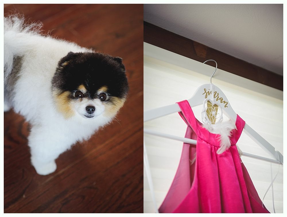 Bride and groom on rocky shoreline, ocean and blue sky background. Groom in suit, bride in white dress, looking at each other.