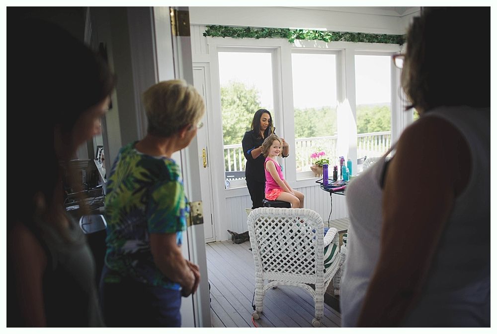 Bride and bridesmaids in navy dresses hold bouquets, posing outdoors.