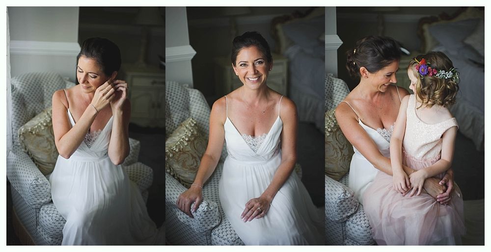 Bride with arms up, making a funny face, groom looking at his hand, cake cutting in background.