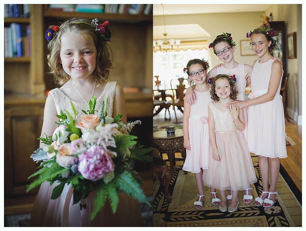Bride with arms up, making a funny face, groom looking at his hand, cake cutting in background.