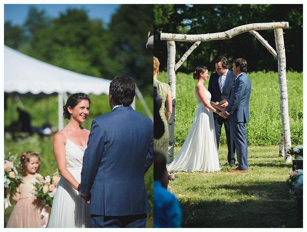 Bride with arms up, making a funny face, groom looking at his hand, cake cutting in background.