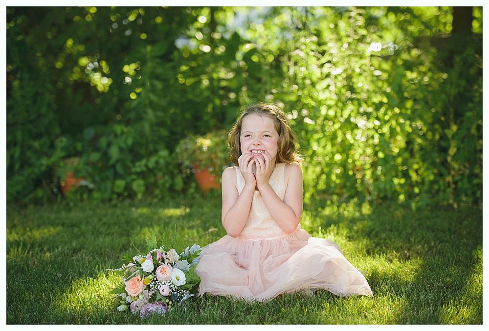 Bride with arms up, making a funny face, groom looking at his hand, cake cutting in background.