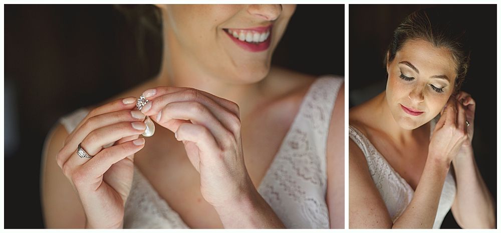 Woman putting on earrings, smiling. Dark background, wearing wedding dress.
