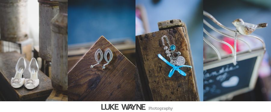 Wedding details: shoes, earrings, charms, and a bird on a chalkboard. Rustic setting with wood and metal elements.