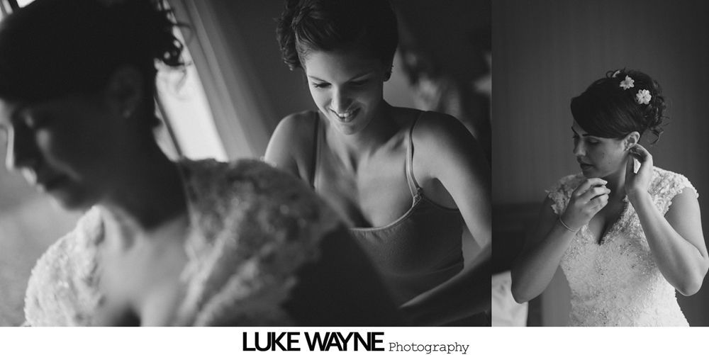 Bride in a white dress, surrounded by bridesmaids in turquoise dresses, smiling in a room.