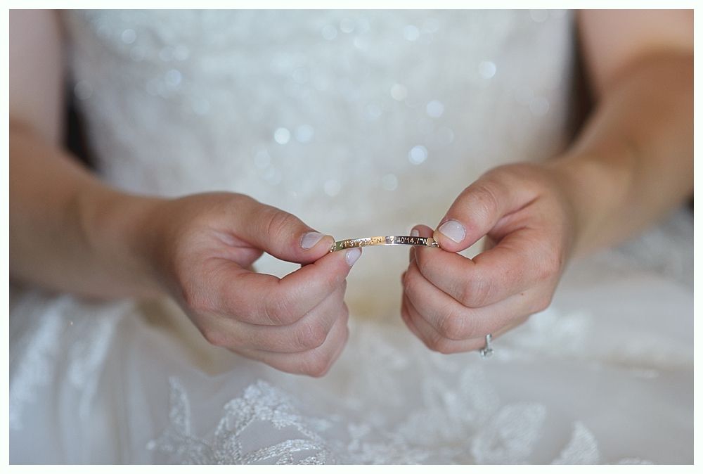 Bride's hands holding a delicate bracelet, close up, soft focus.
